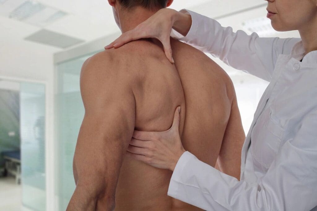 A person is holding their back while another person holds out his hand.